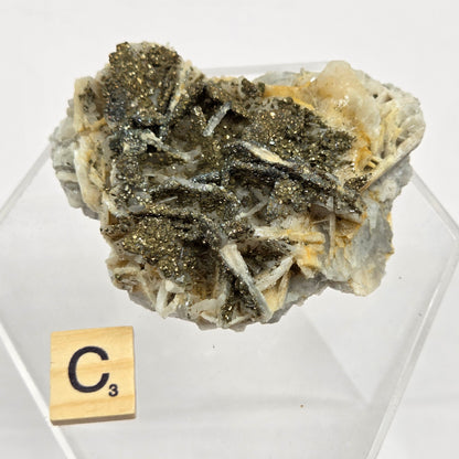Mineral sample on a clear stand with a label