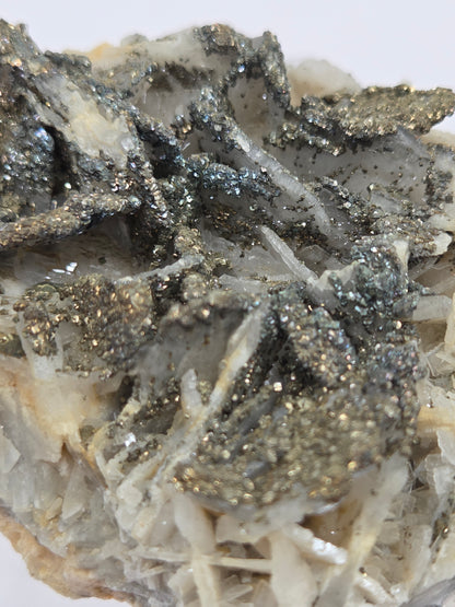Close-up of a crystal formation with pyrite on a white background