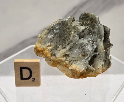 Mineral sample on a clear stand with a blurred background