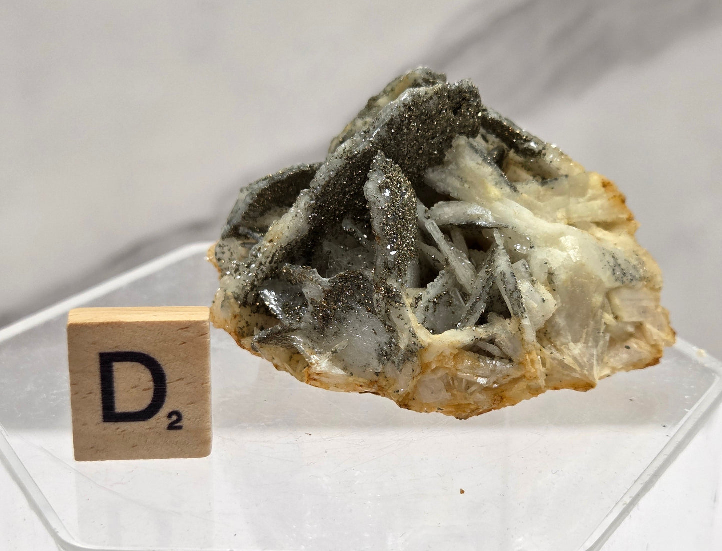 Mineral sample with a clear acrylic stand on a white background