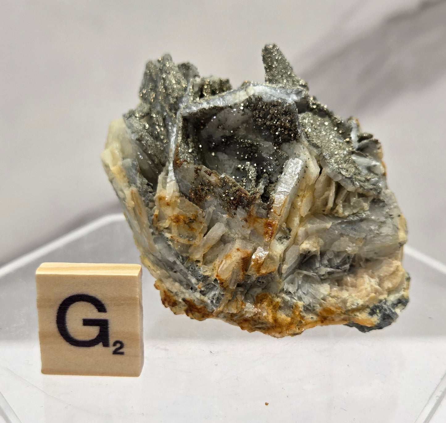 Mineral sample with a wooden block labeled 'G2' on a white background