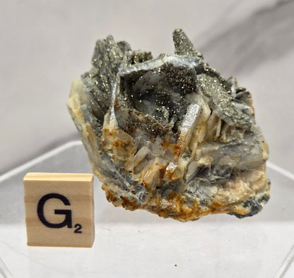 Mineral sample with a wooden block labeled 'G2' on a white background