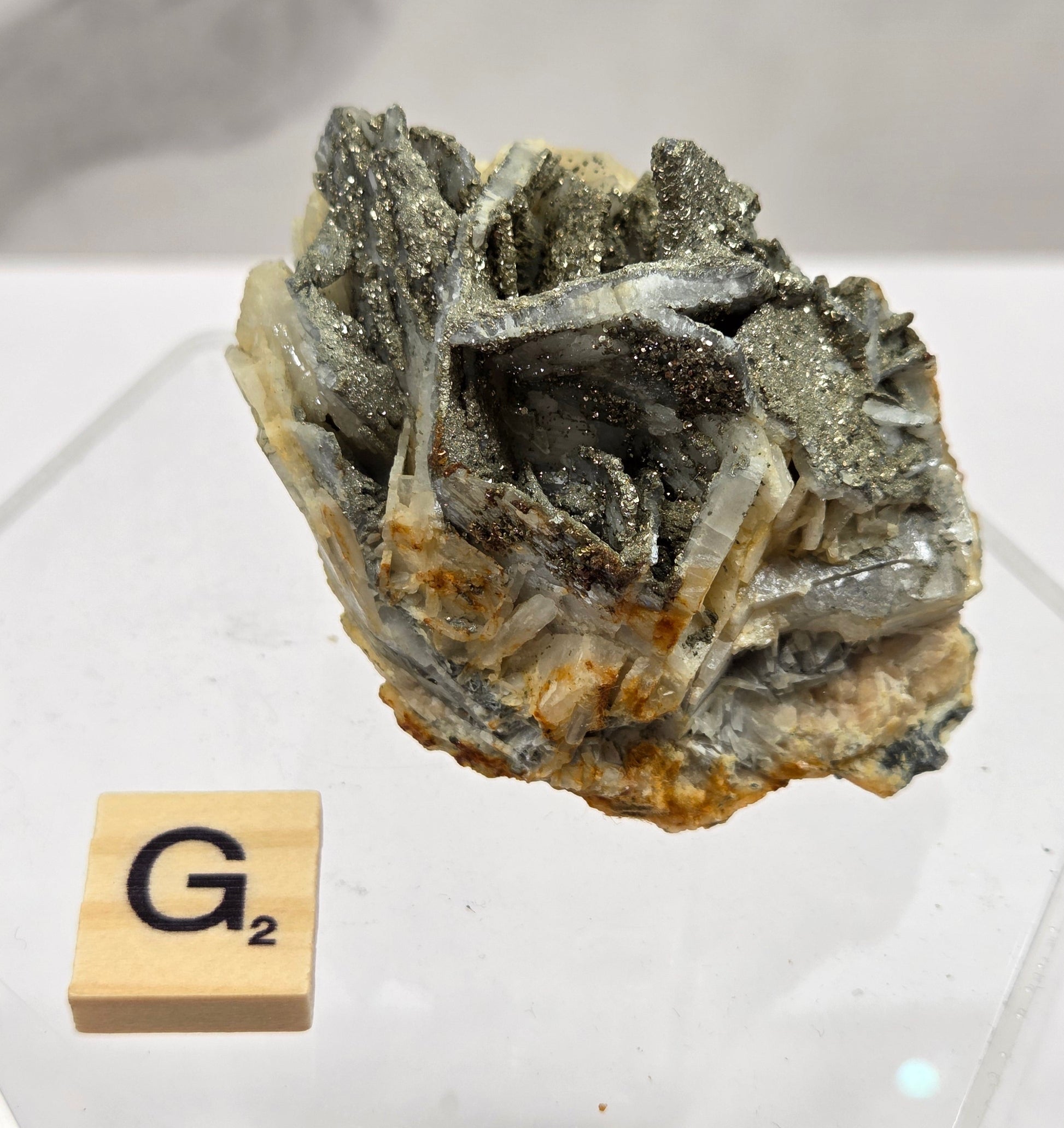 Mineral sample on a white background with a wooden block labeled 'G2'.
