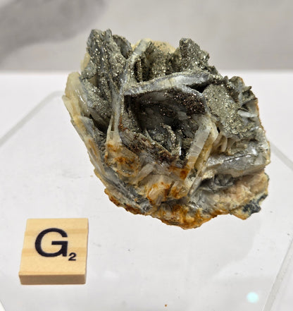 Mineral sample on a white background with a wooden block labeled 'G2'.