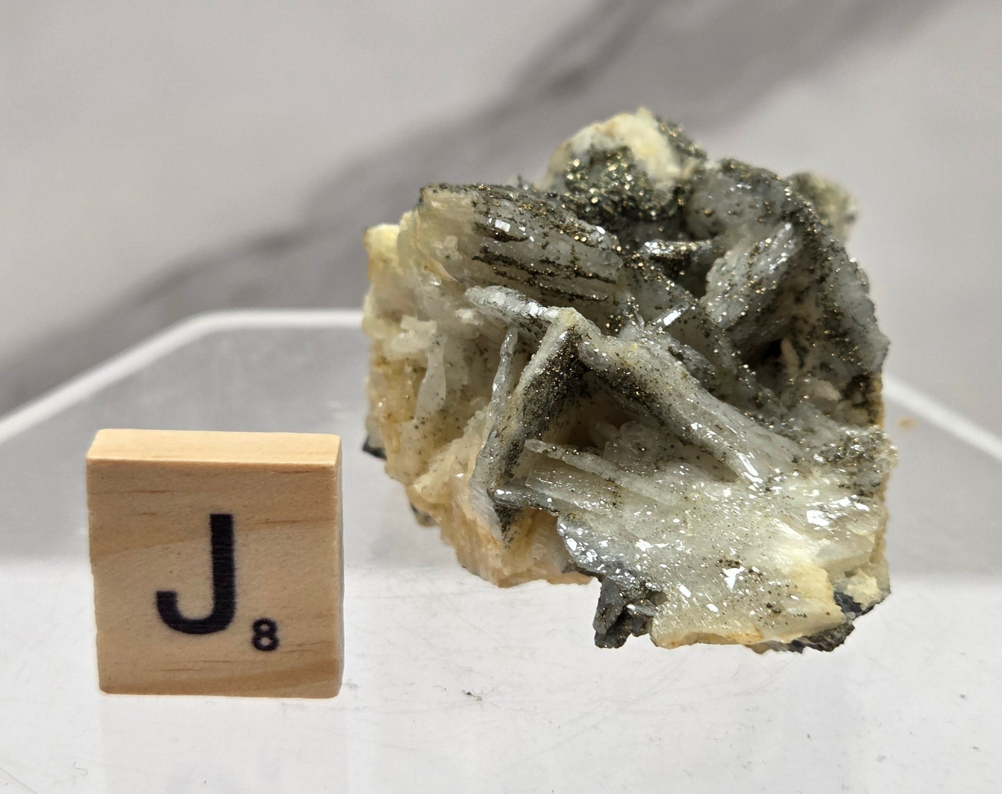 Mineral sample on a white background with a wooden block displaying the number 8.