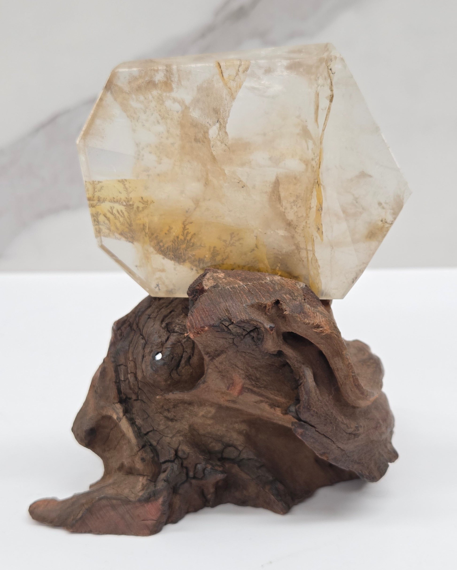 Dendritic Quartz free form on a wood stand against a white background