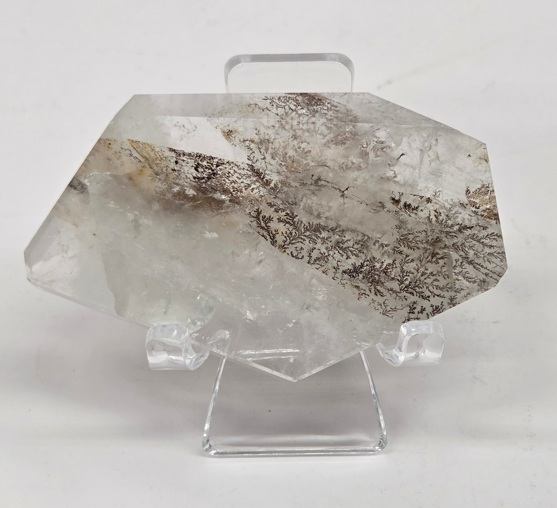 Dendritic Quartz free form on an acrylic stand against a white background