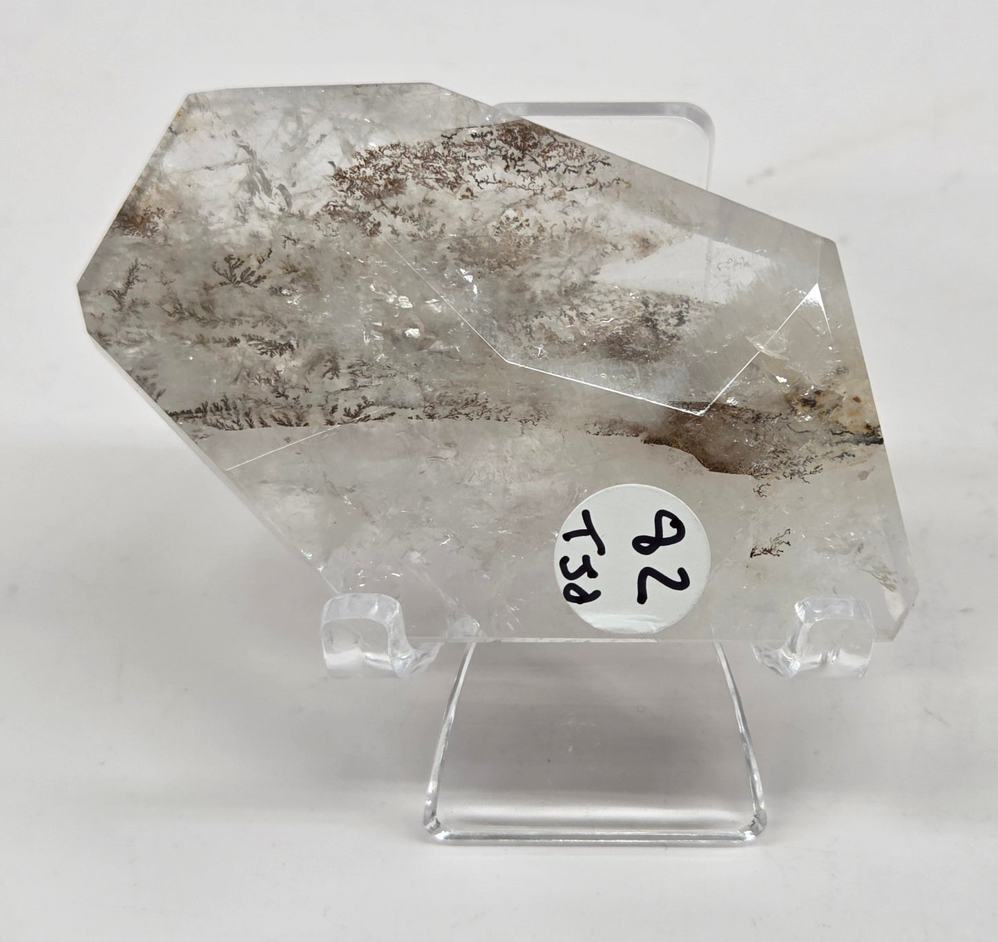 Dendritic Quartz free form on an acrylic stand against a white background