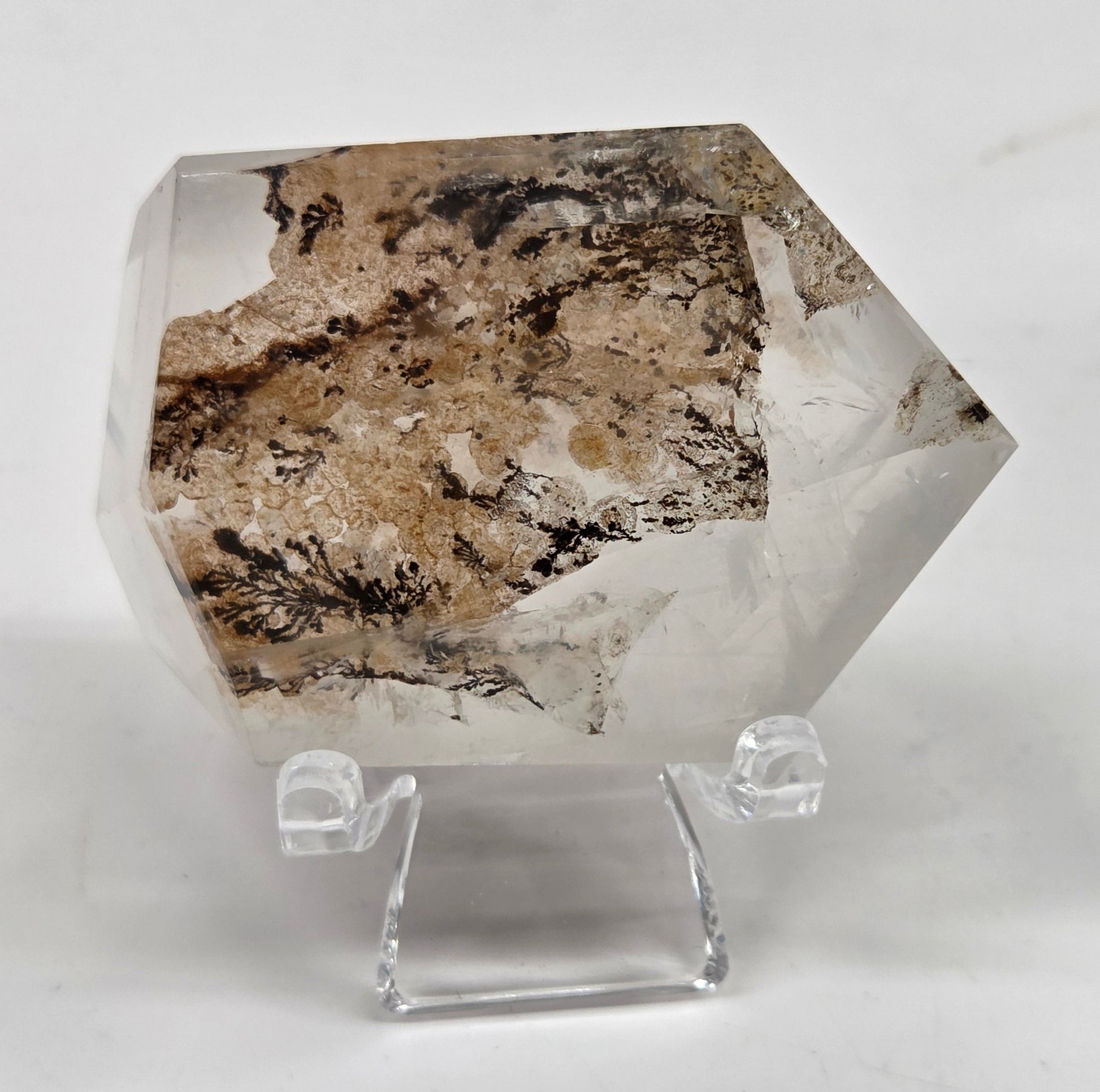 Dendritic Quartz free form on an acrylic stand against a white background