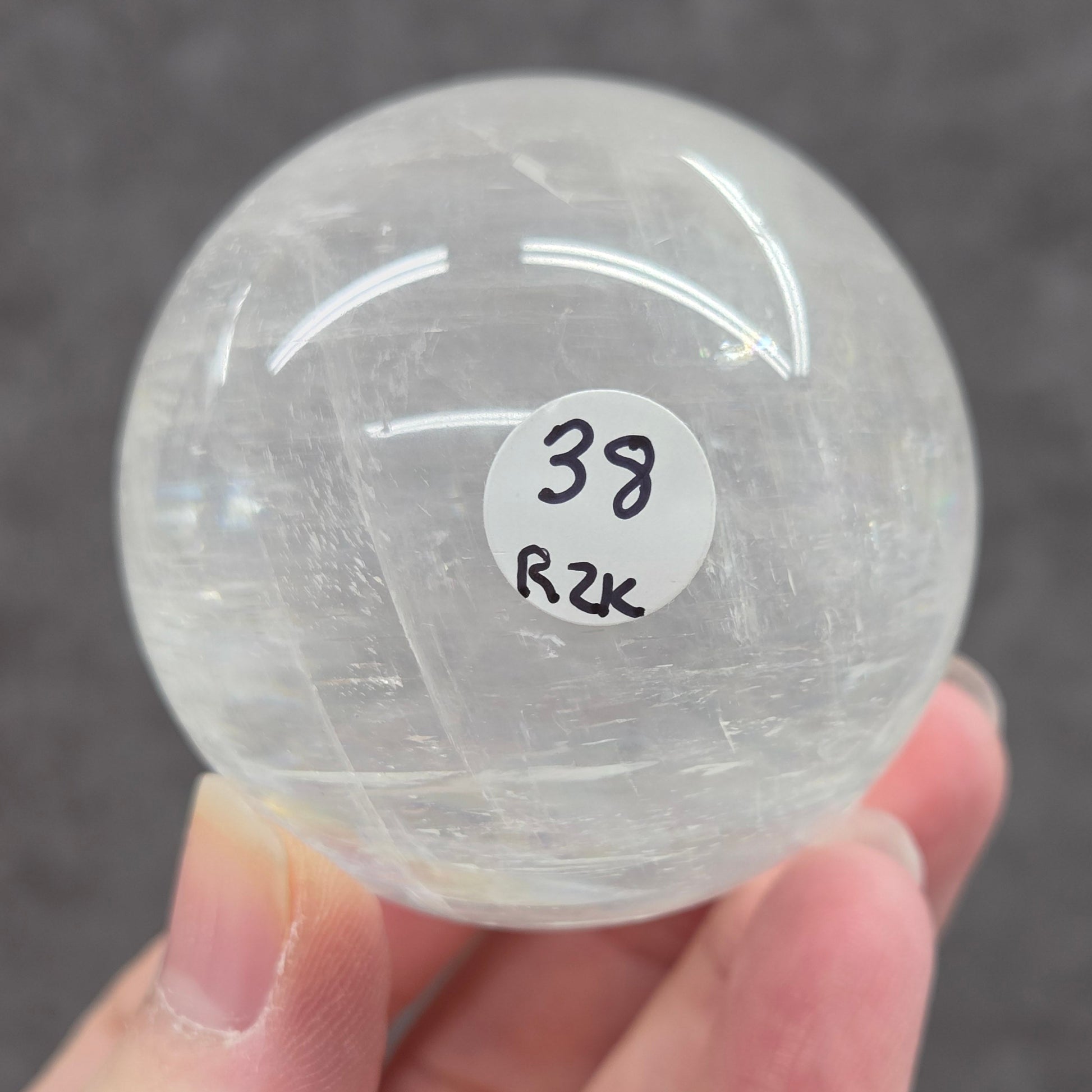 Clear crystal ball held by a hand with a blurred background