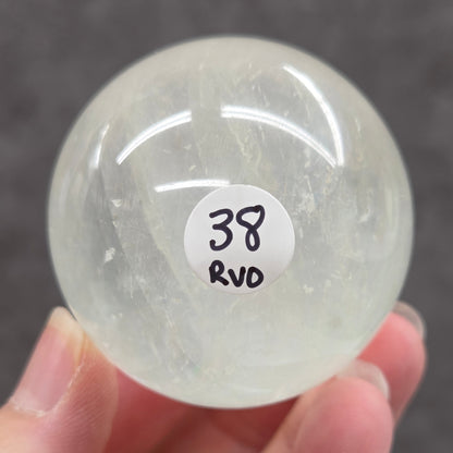 Clear crystal ball held by a hand with a label on a dark background