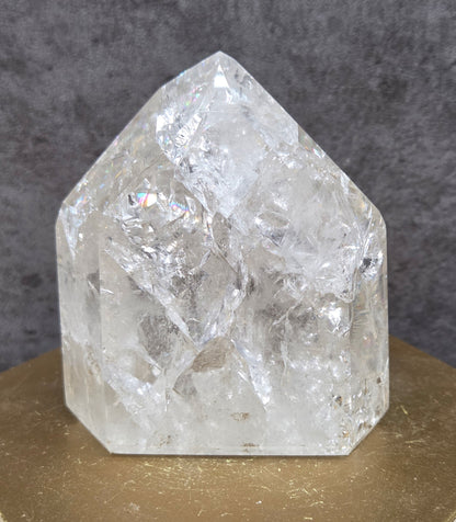 Clear Quartz crystal tower displayed against a neutral background.
