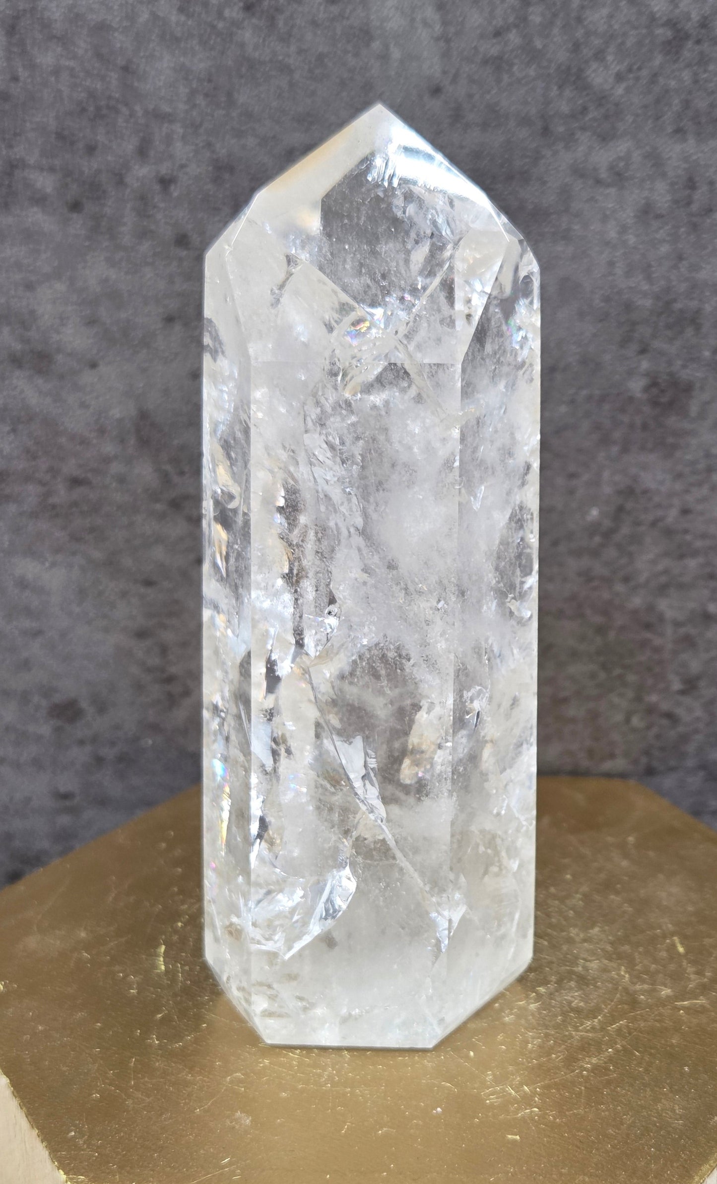 Clear Quartz crystal tower displayed against a neutral background.