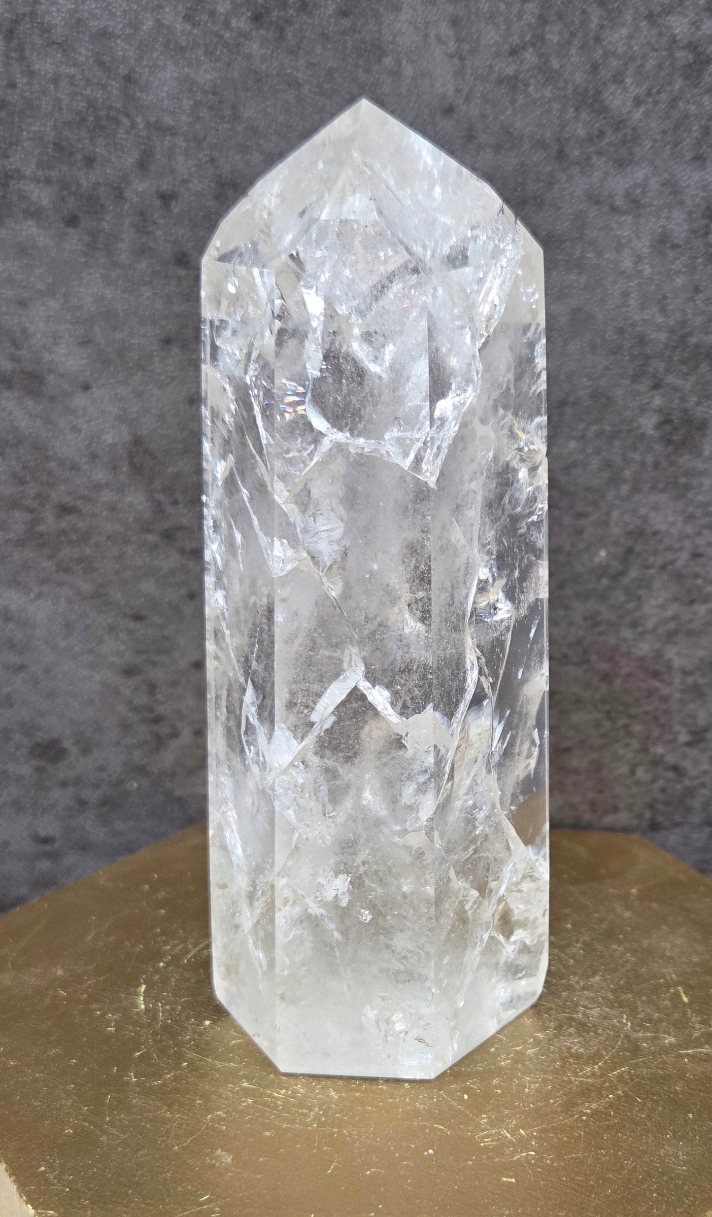 Clear Quartz crystal tower displayed against a neutral background.
