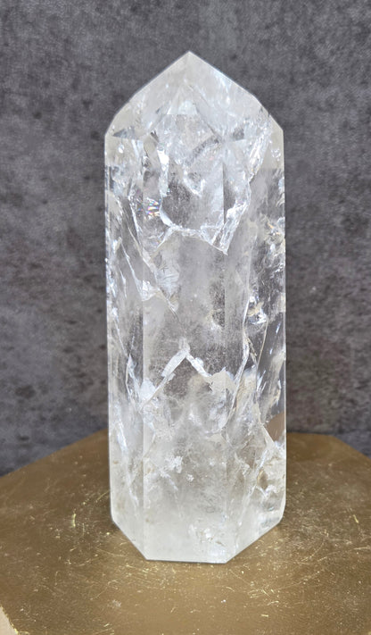 Clear Quartz crystal tower displayed against a neutral background.