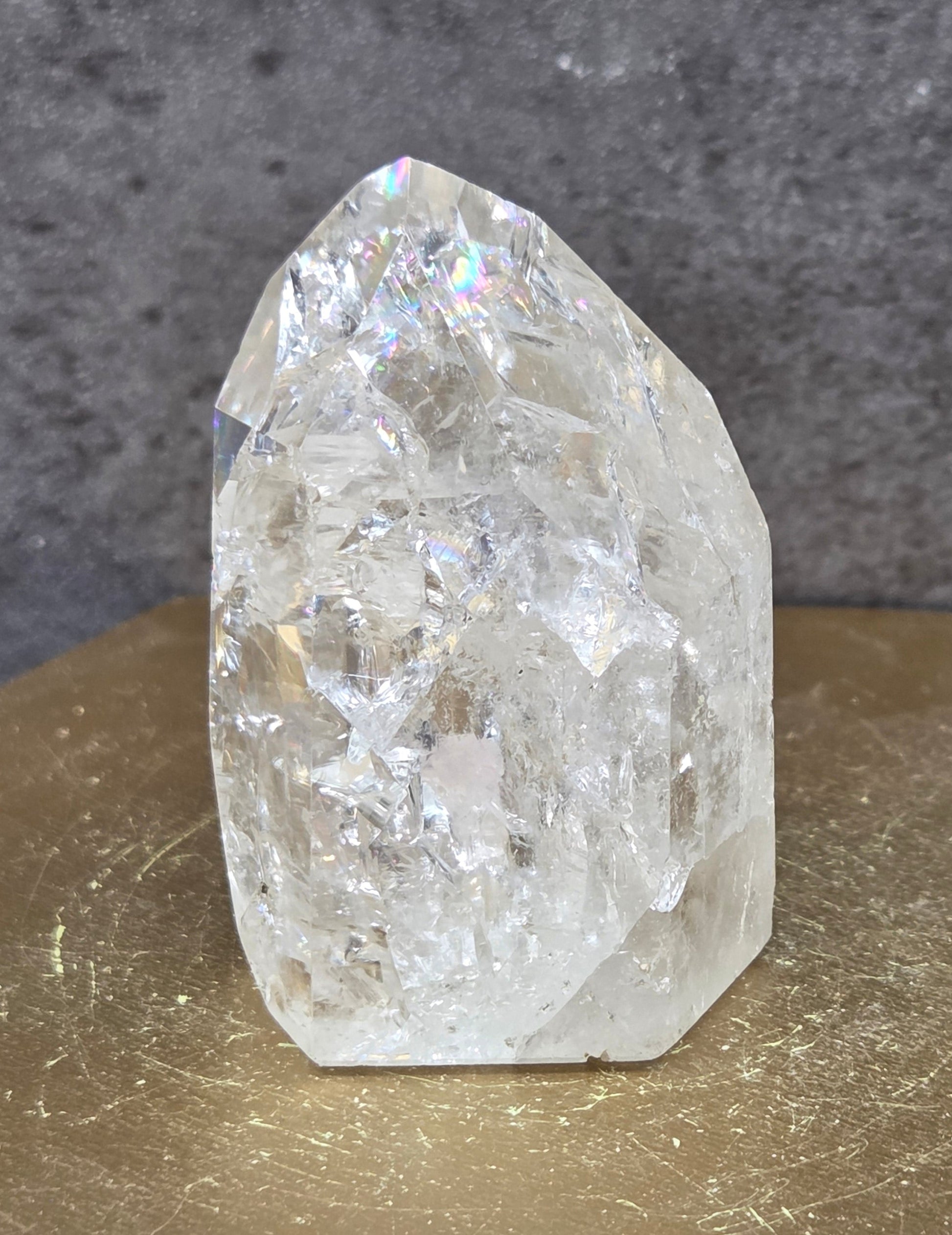 Clear Quartz crystal tower displayed against a neutral background.