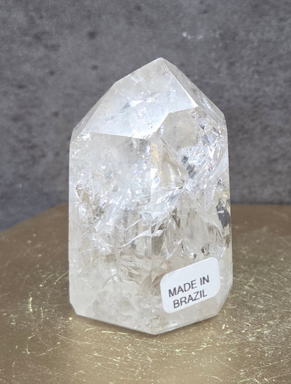 Clear Quartz crystal tower displayed against a neutral background.