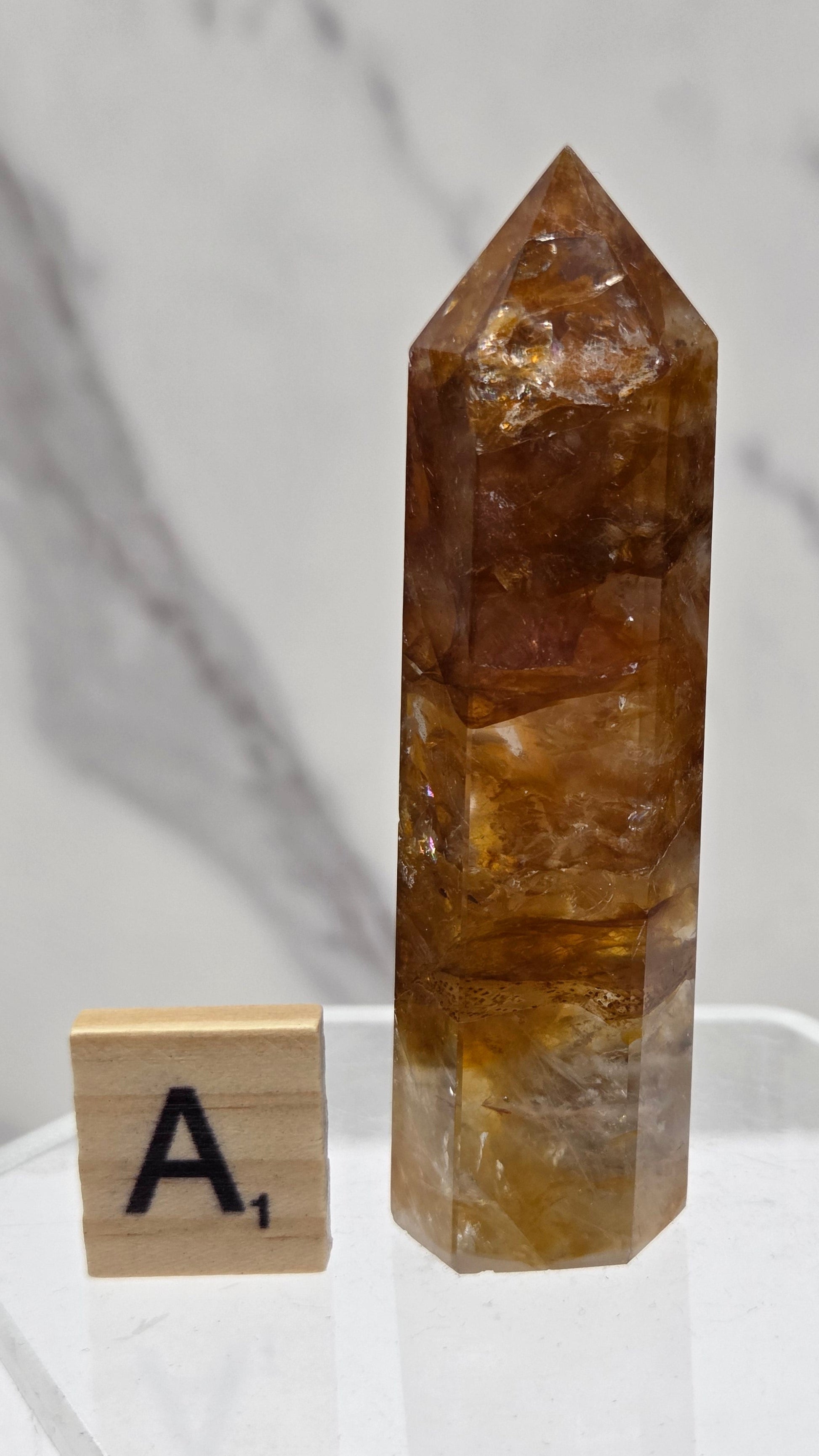 Golden Healer tower on a clear stand against a white background