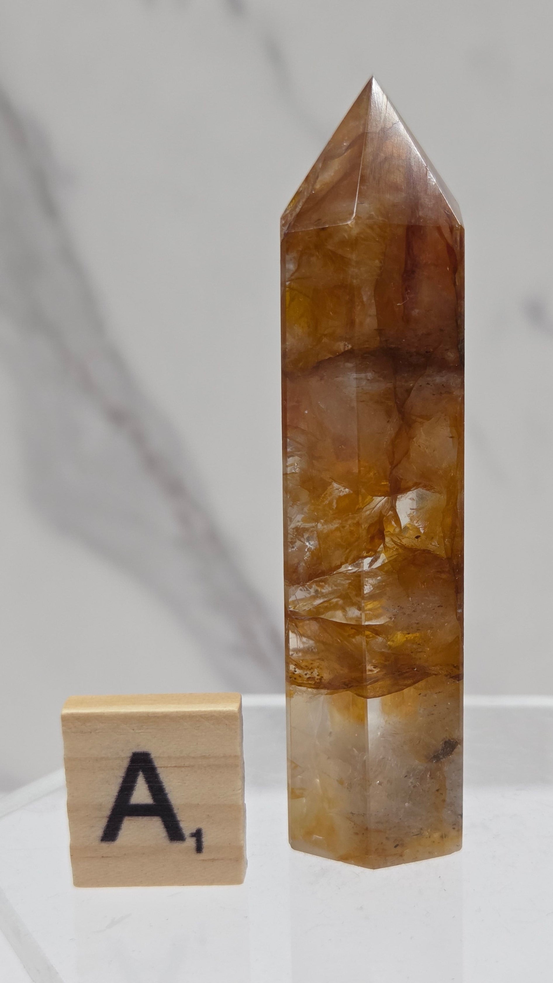 Golden Healer tower on a clear stand against a white background