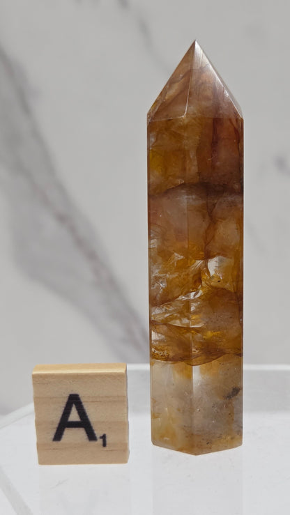 Golden Healer tower on a clear stand against a white background