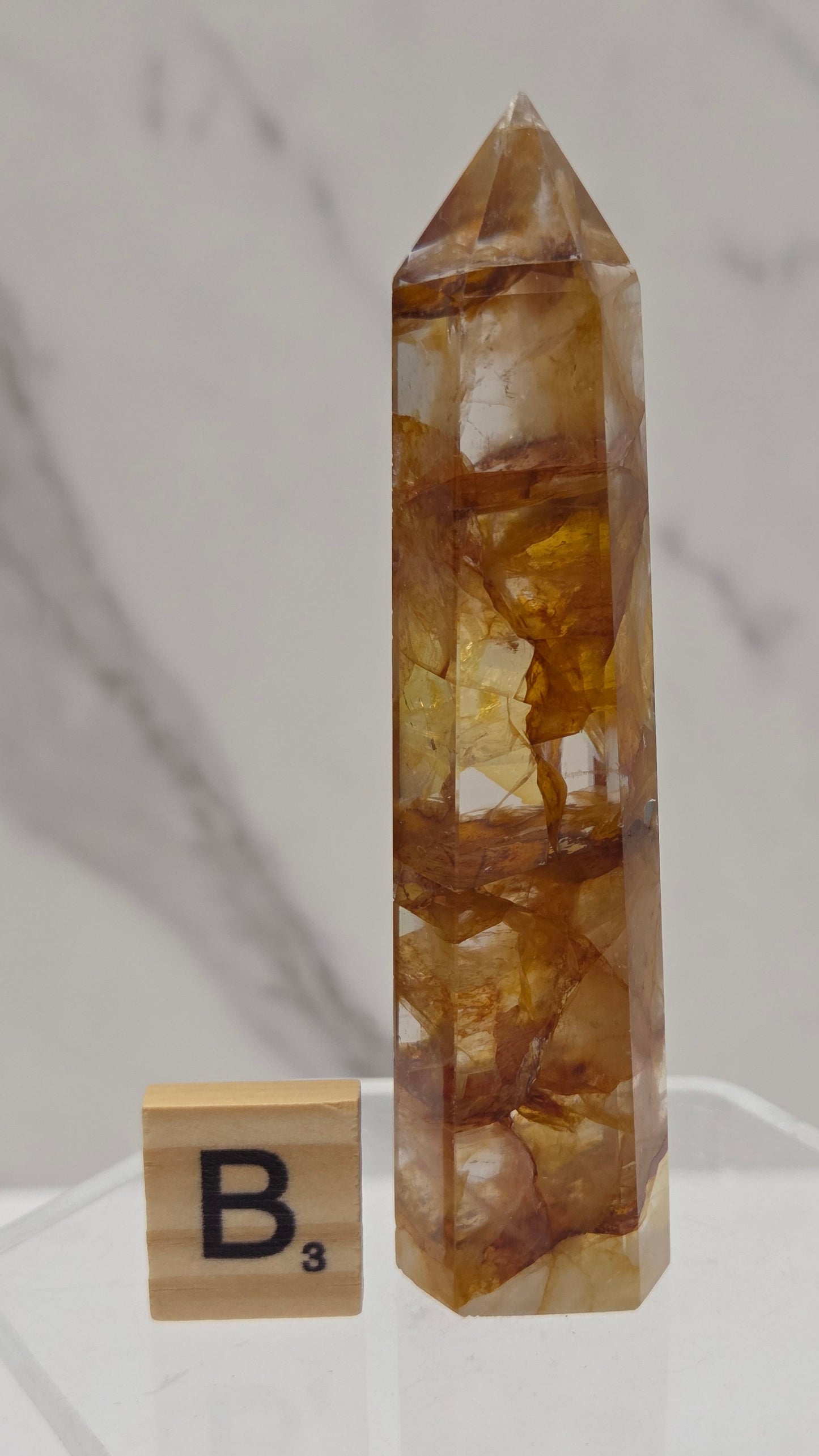 Golden Healer tower on a clear stand against a white background