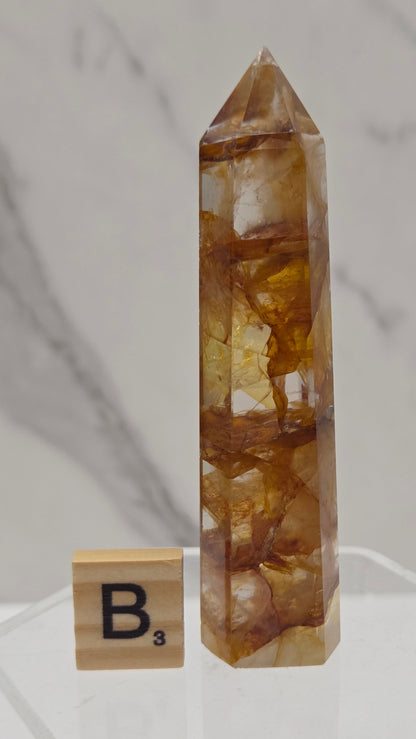 Golden Healer tower on a clear stand against a white background
