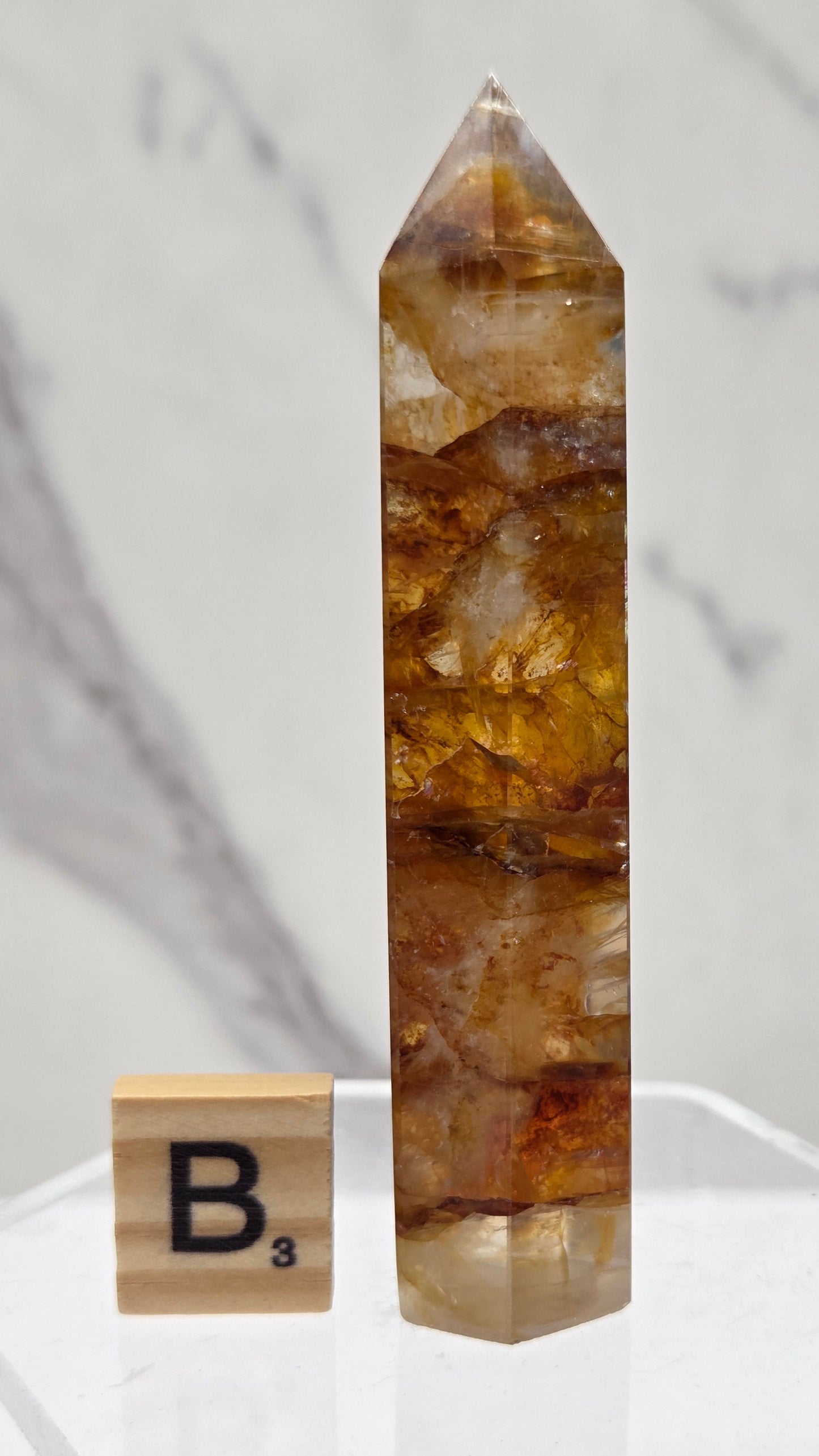 Golden Healer tower on a clear stand against a white background