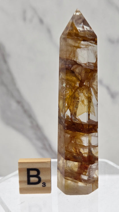 Golden Healer tower on a clear stand against a white background
