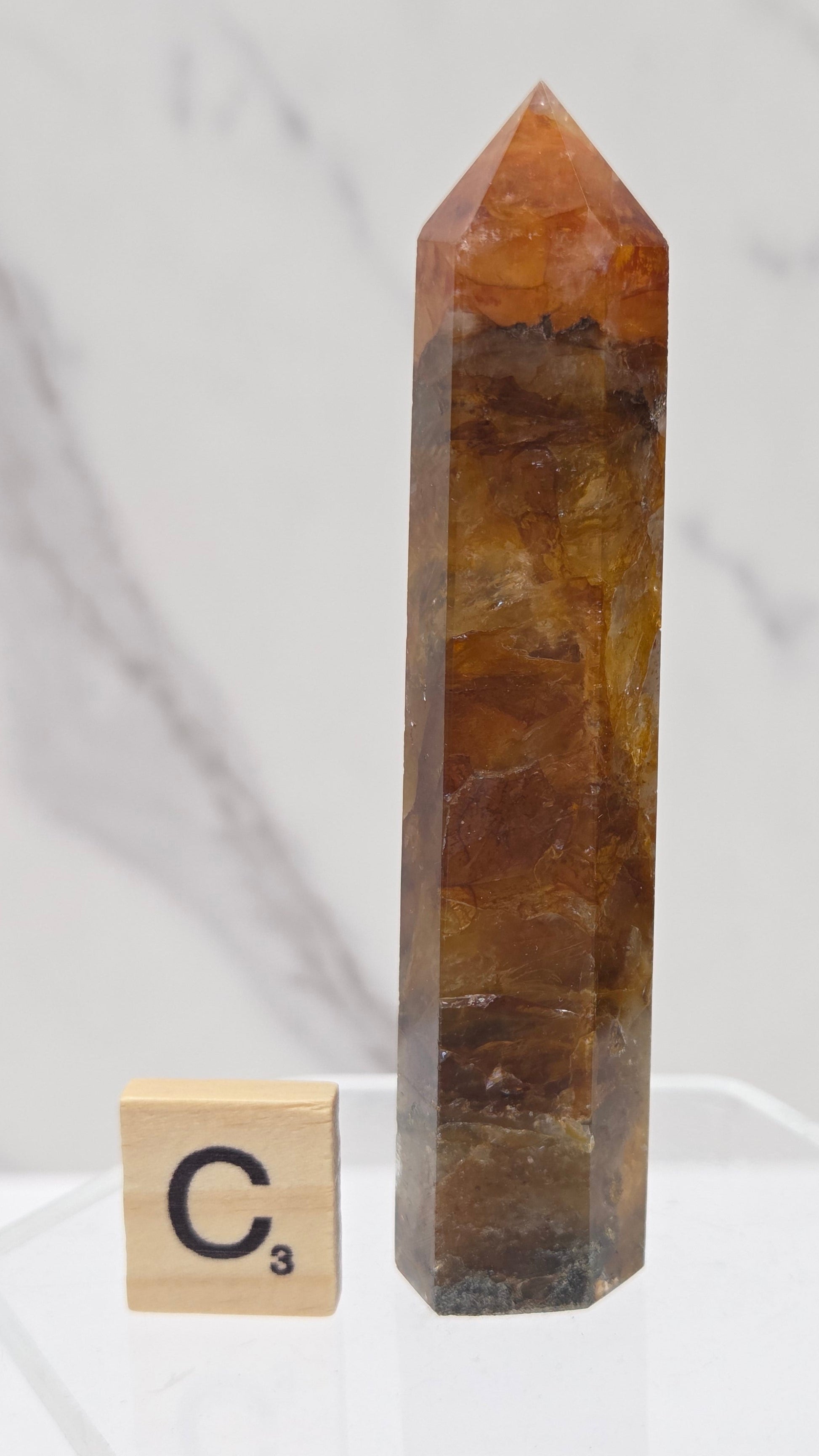 Golden Healer tower on a clear stand against a white background