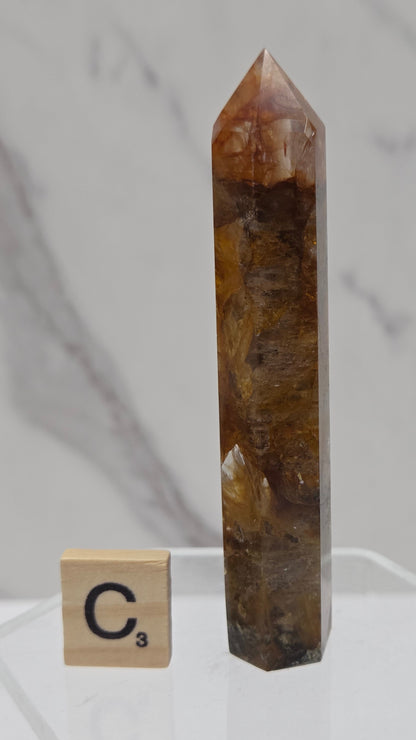 Golden Healer tower on a clear stand against a white background