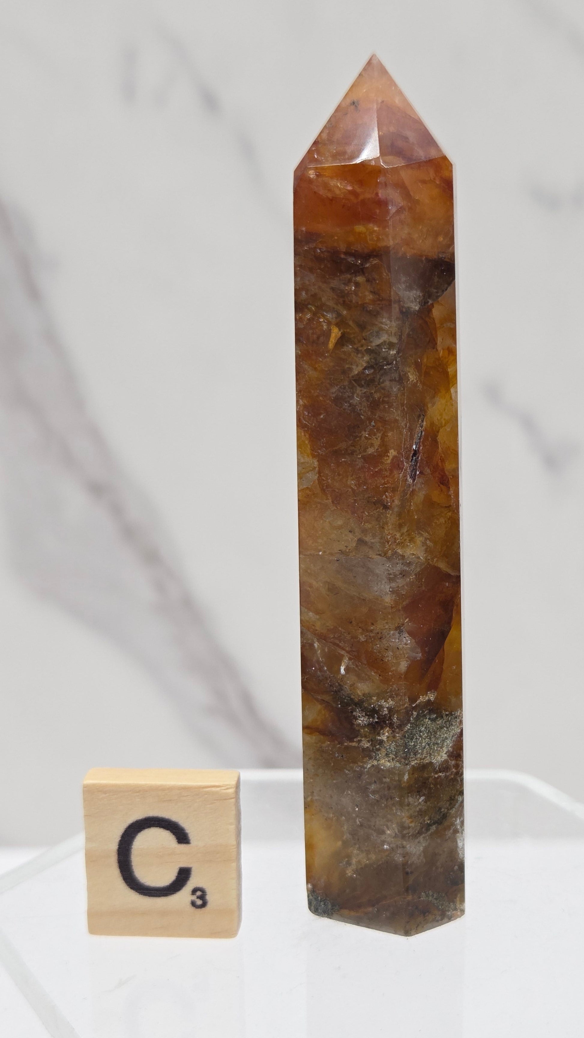 Golden Healer tower on a clear stand against a white background