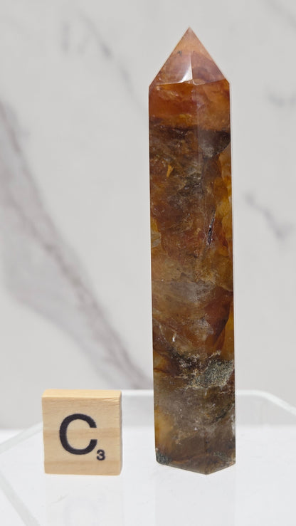 Golden Healer tower on a clear stand against a white background