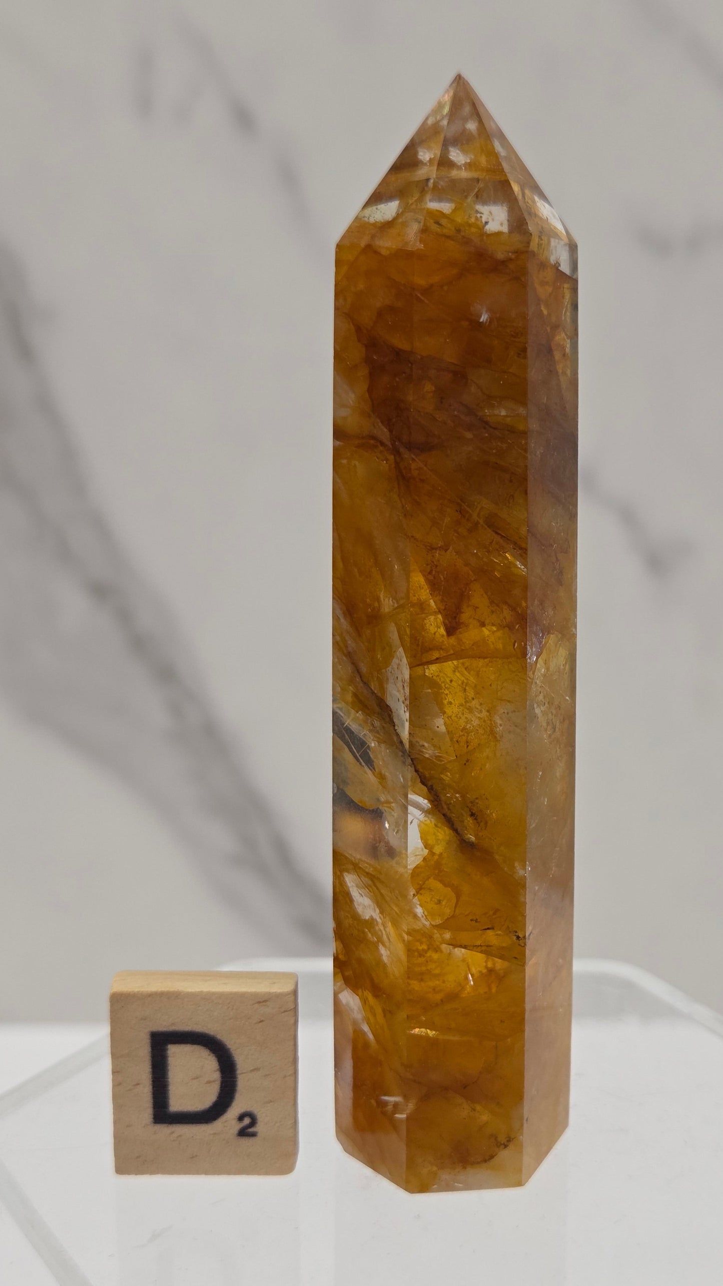 Golden Healer tower on a clear stand against a white background