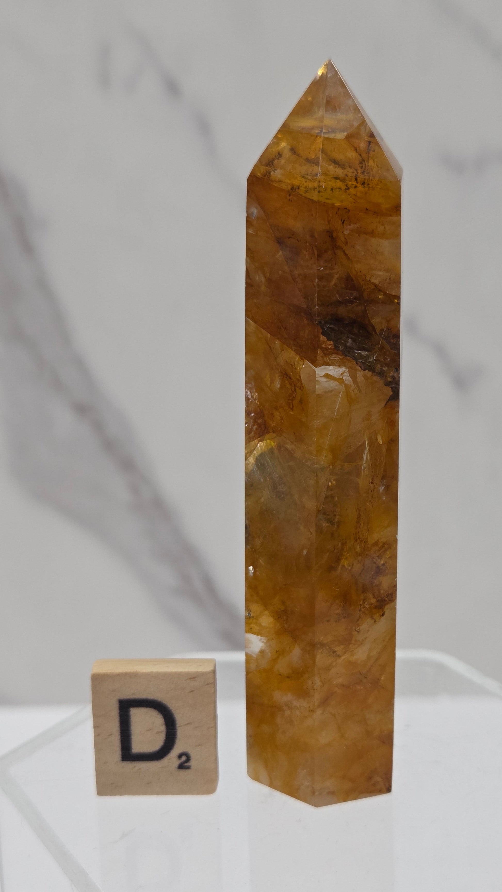 Golden Healer tower on a clear stand against a white background