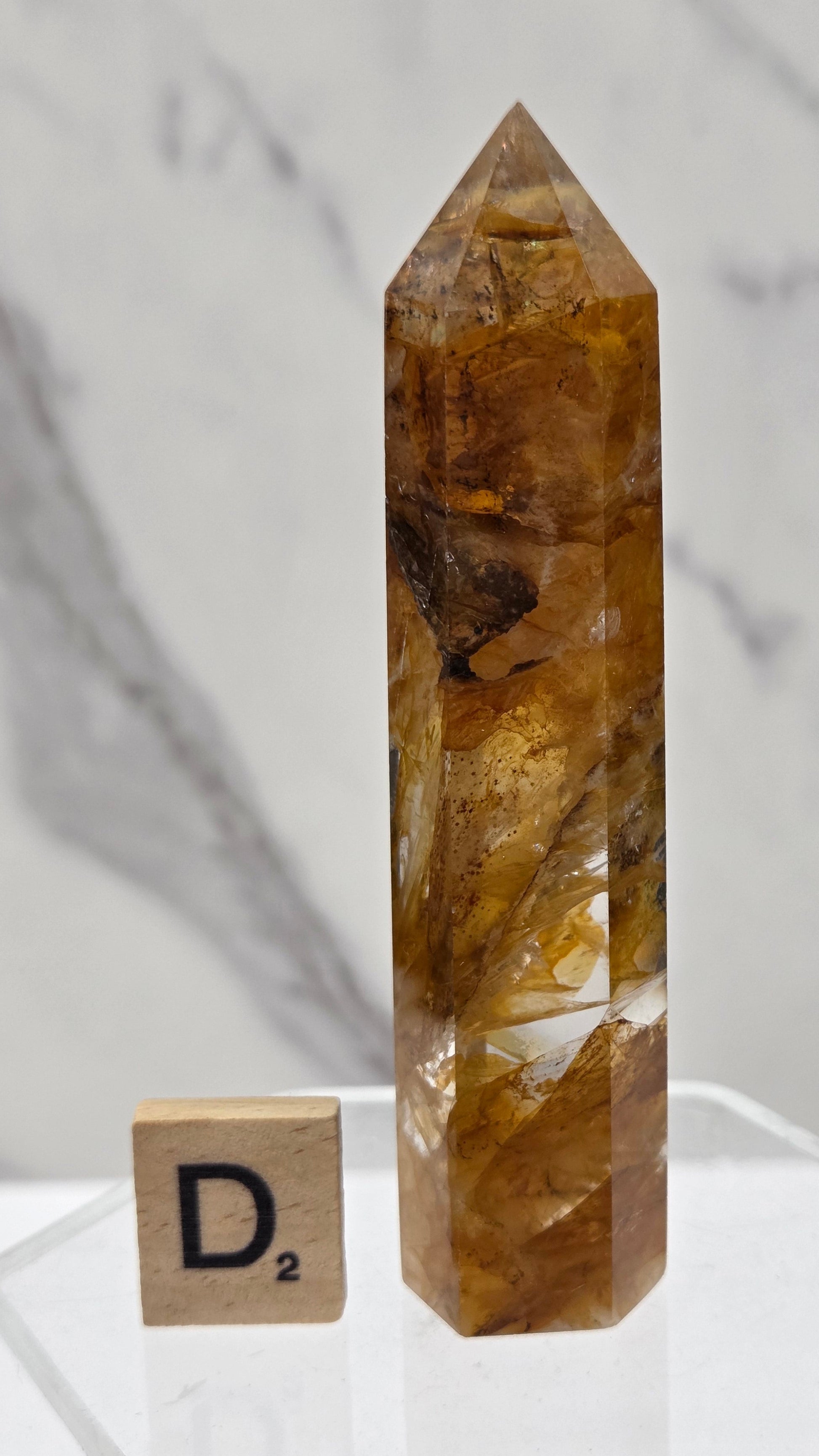 Golden Healer tower on a clear stand against a white background