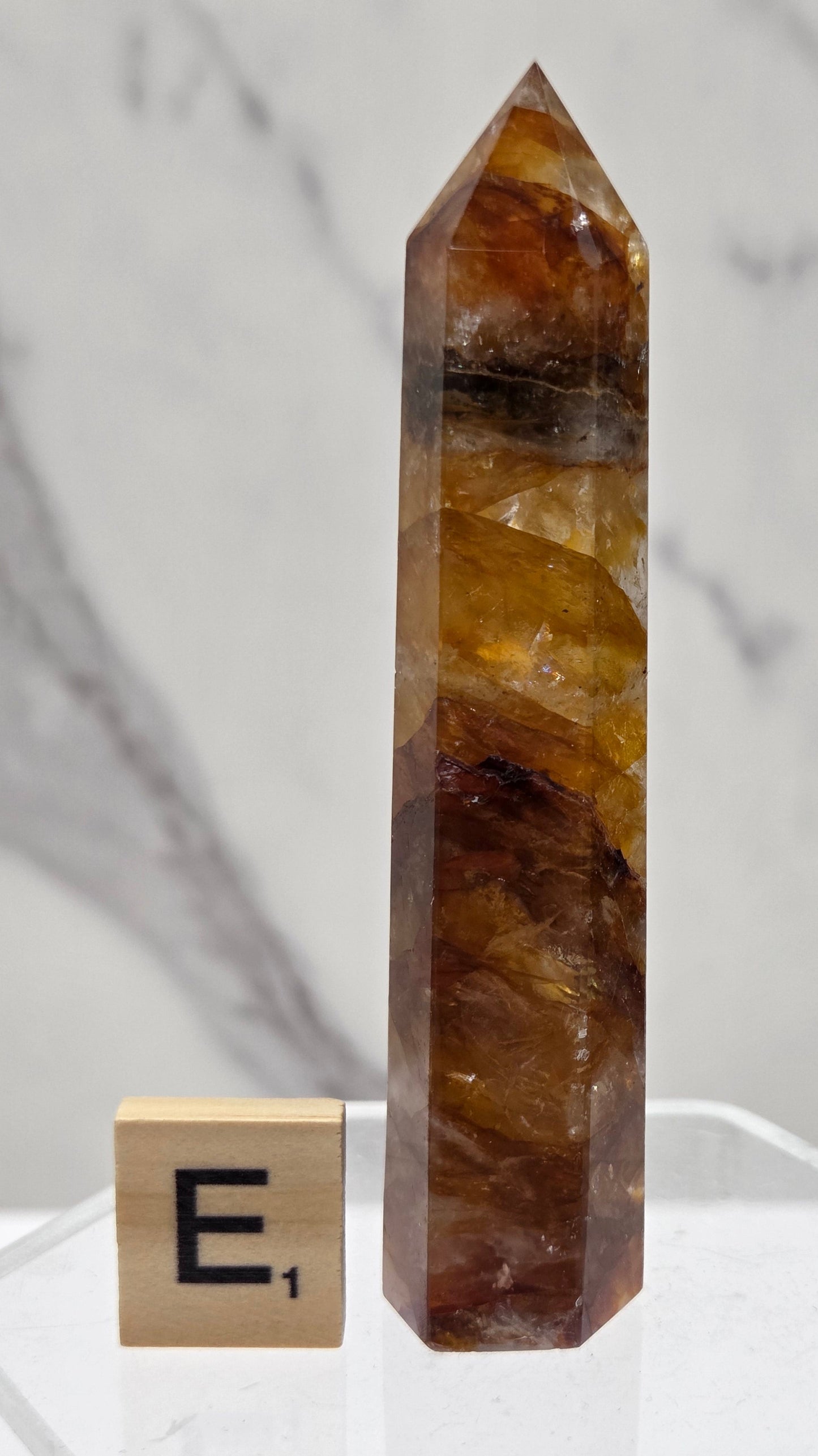 Golden Healer tower on a clear stand against a white background