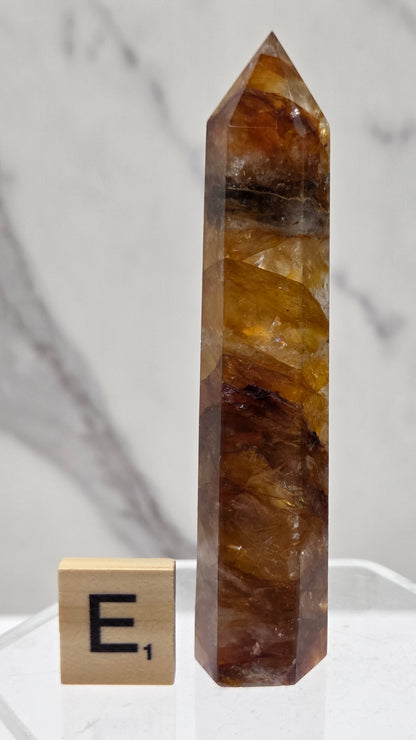 Golden Healer tower on a clear stand against a white background