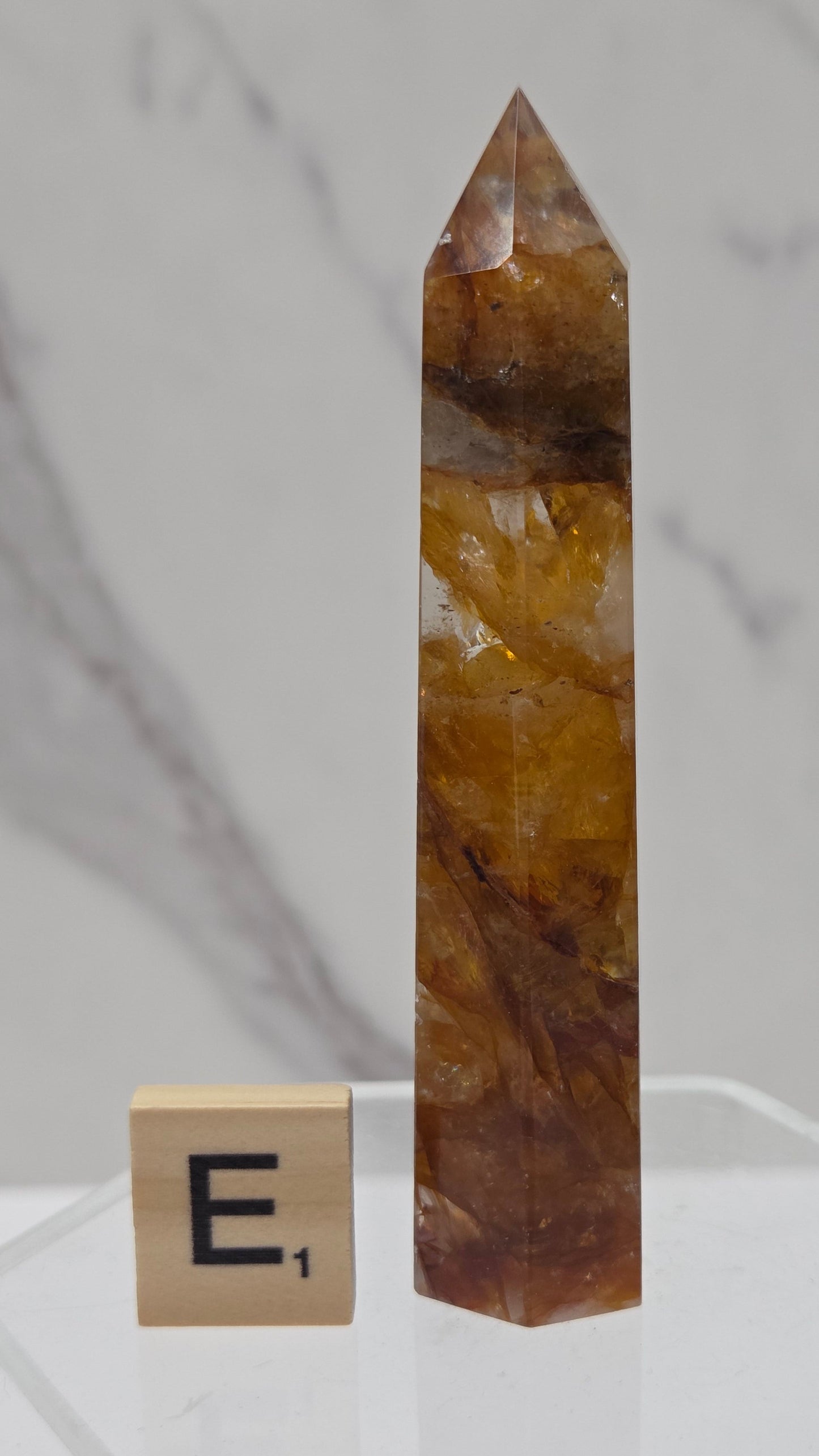 Golden Healer tower on a clear stand against a white background