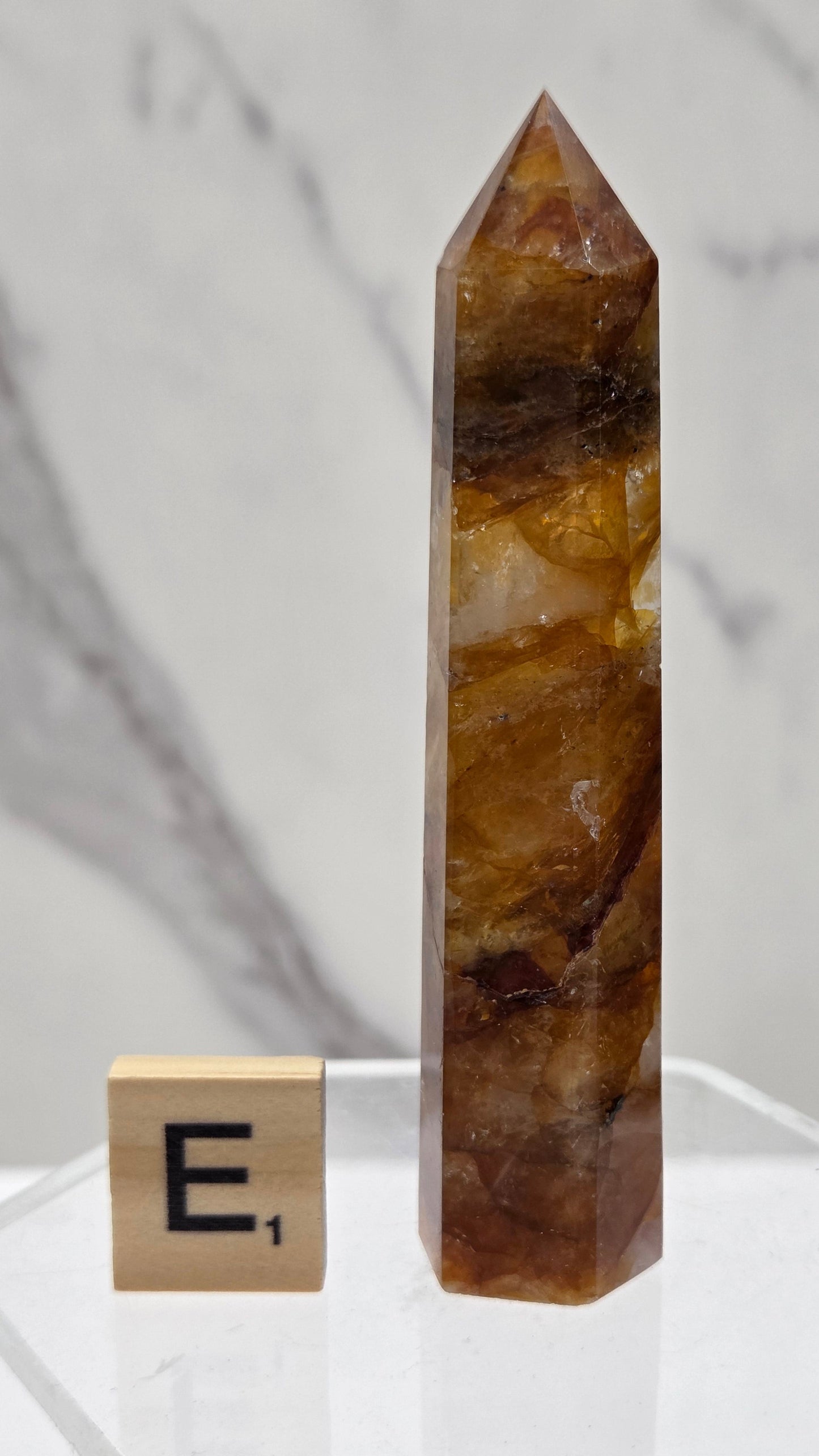 Golden Healer tower on a clear stand against a white background