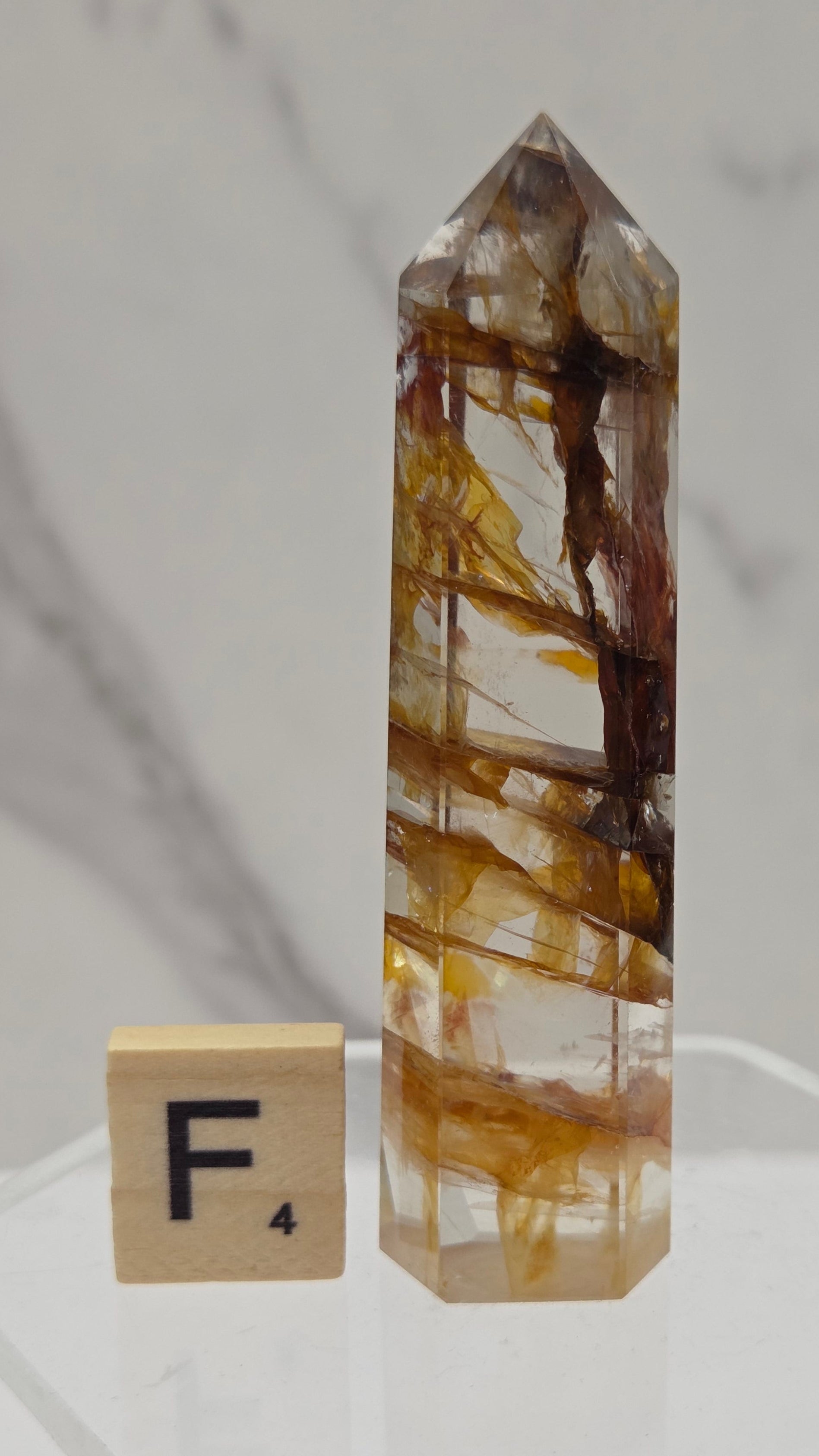 Golden Healer tower on a clear stand against a white background