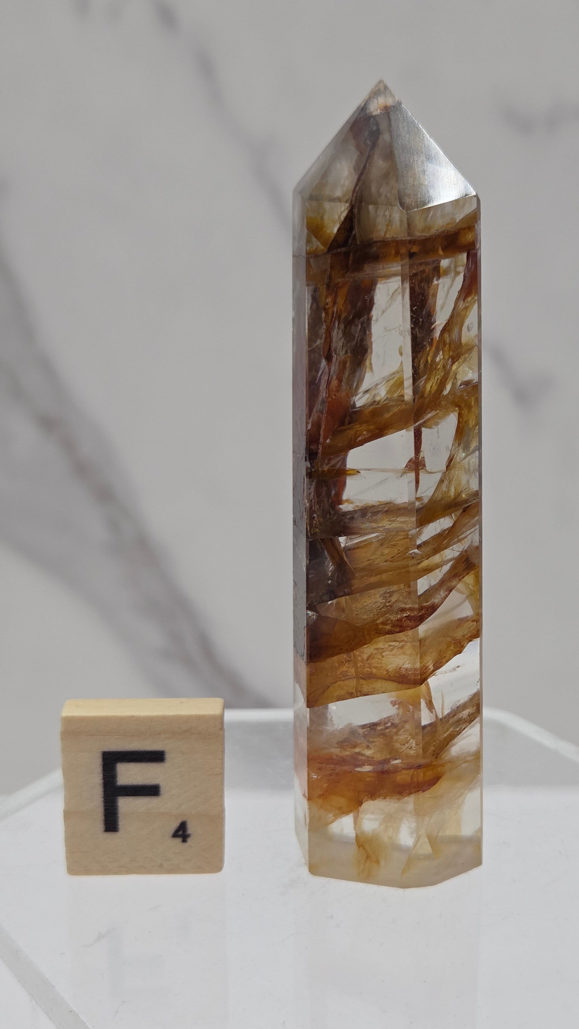 Golden Healer tower on a clear stand against a white background