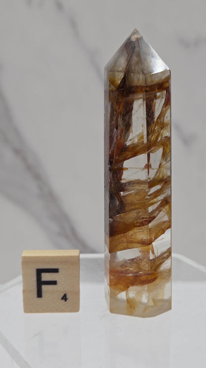 Golden Healer tower on a clear stand against a white background
