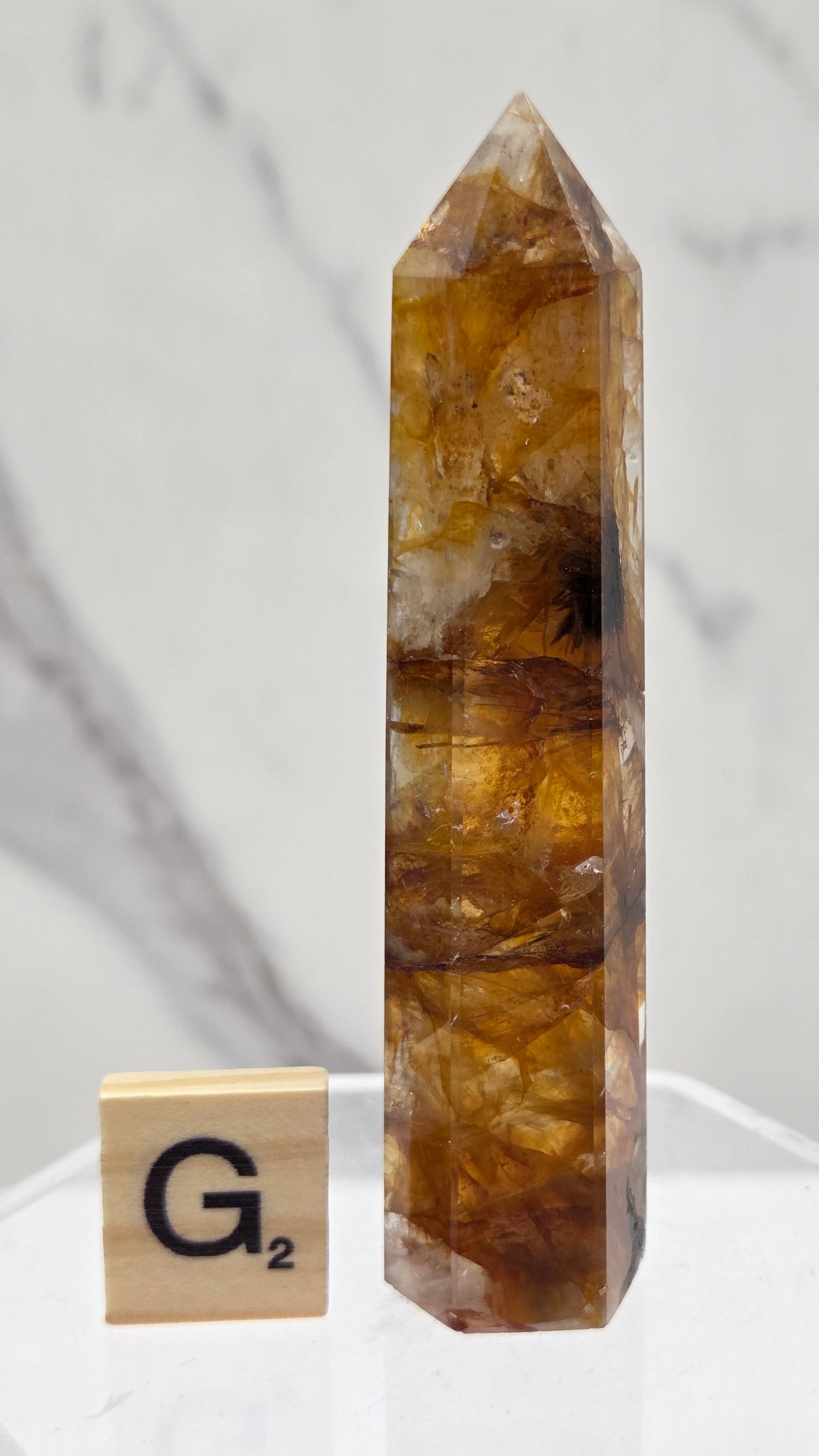 Golden Healer tower on a clear stand against a white background