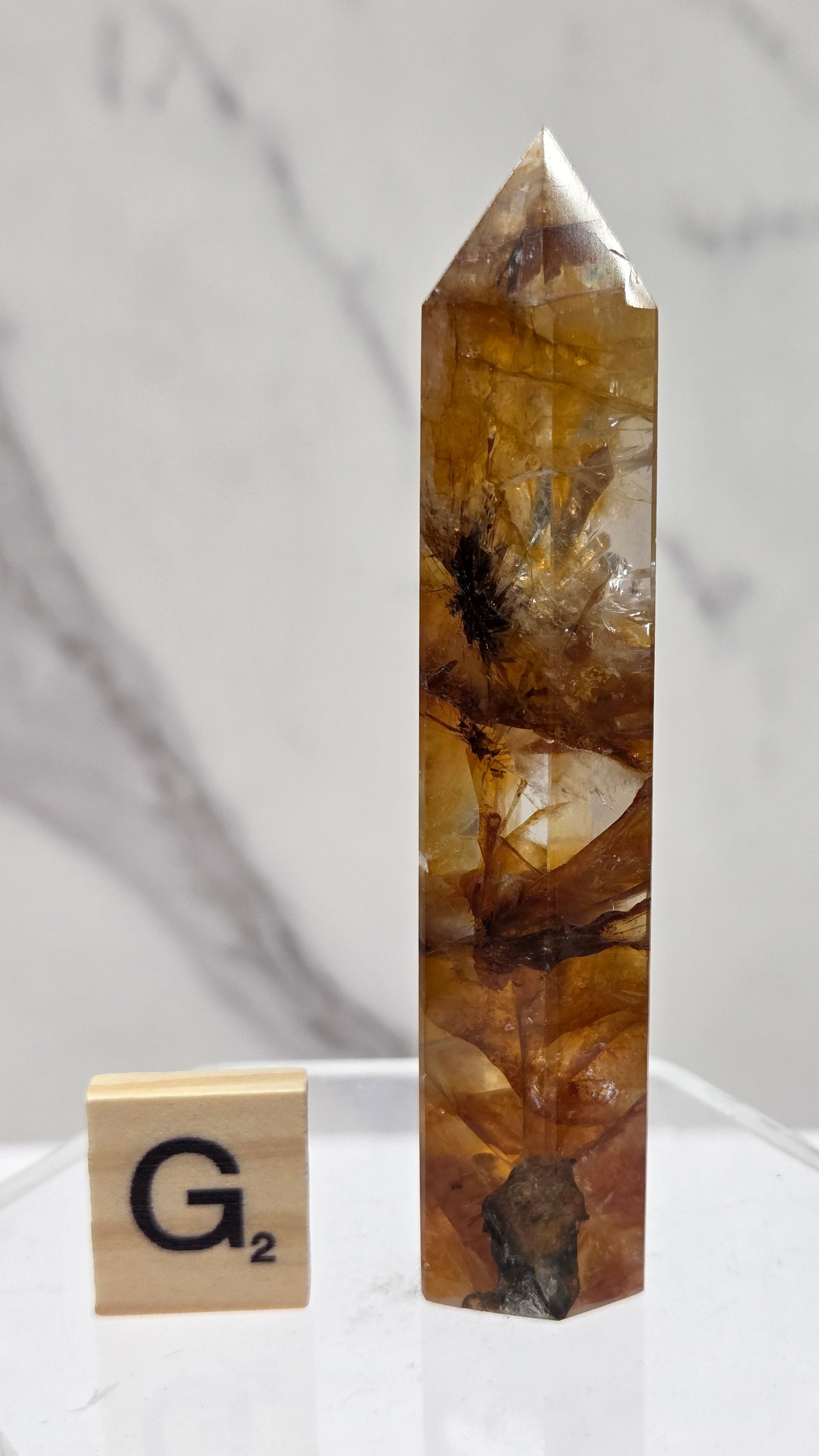 Golden Healer tower on a clear stand against a white background