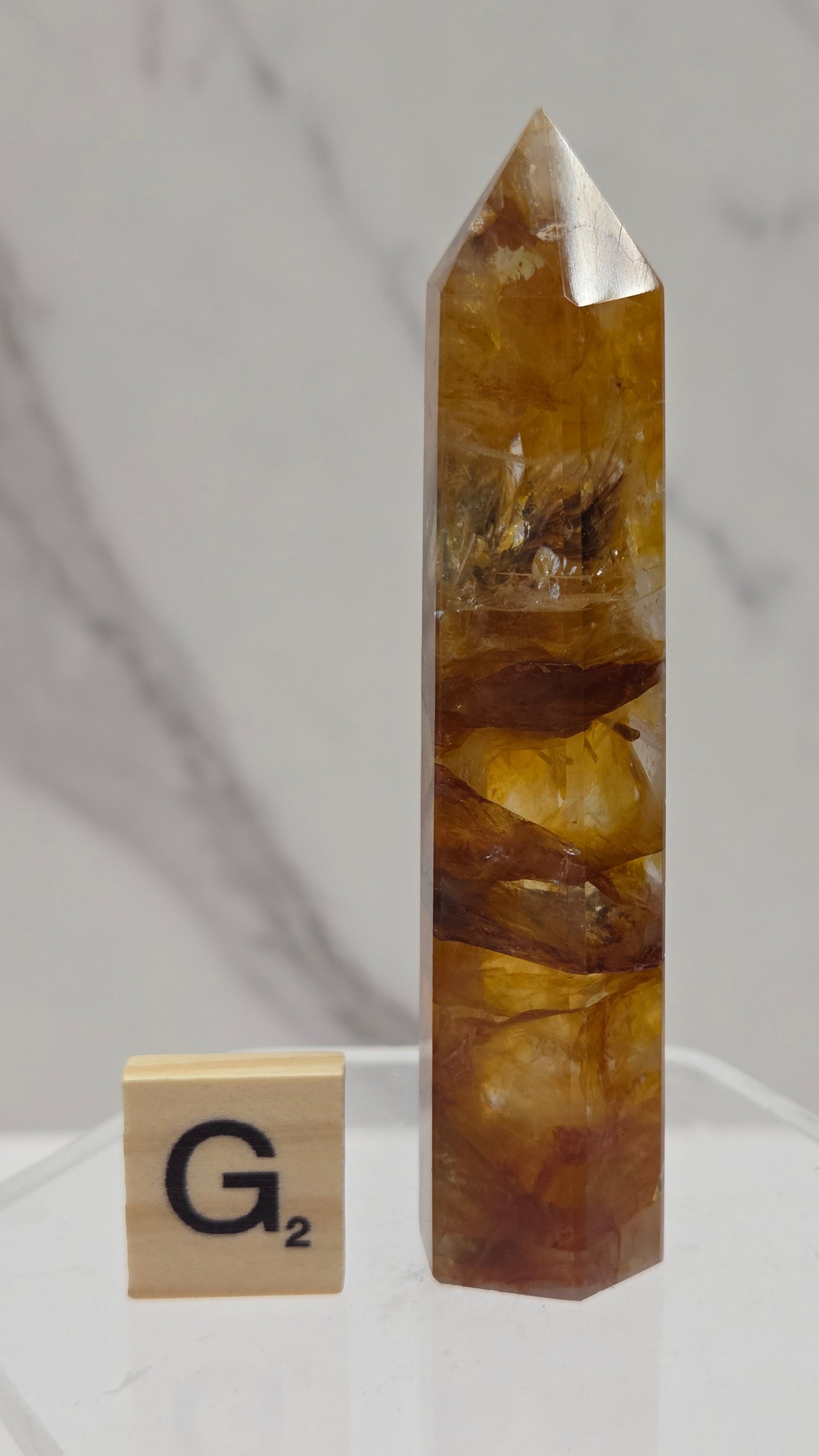Golden Healer tower on a clear stand against a white background