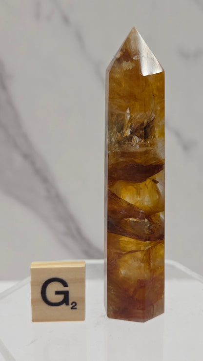 Golden Healer tower on a clear stand against a white background