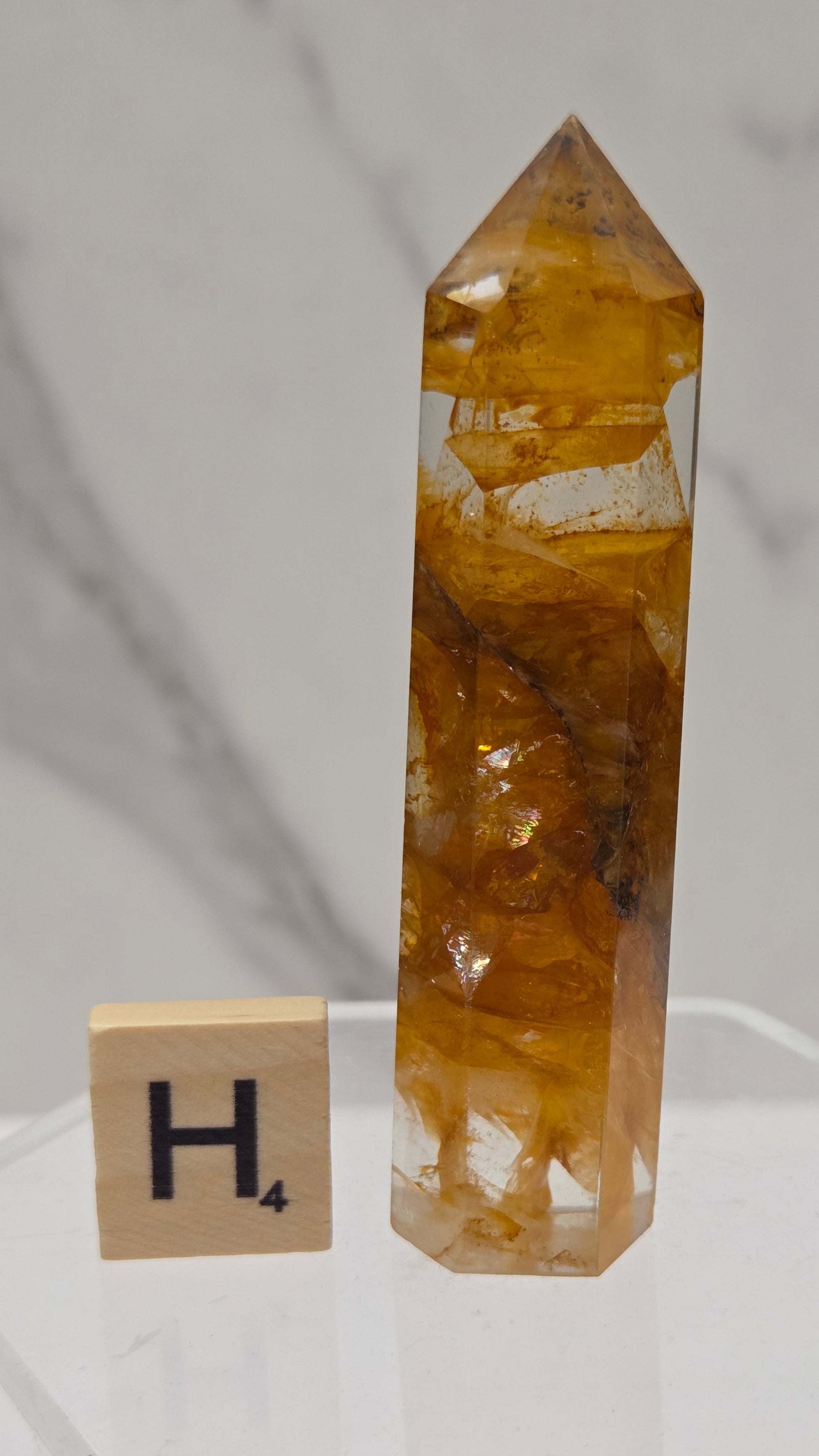 Golden Healer tower on a clear stand against a white background