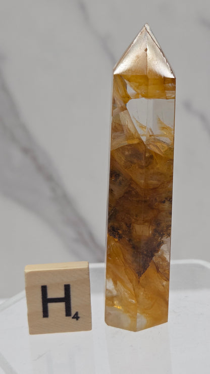 Golden Healer tower on a clear stand against a white background