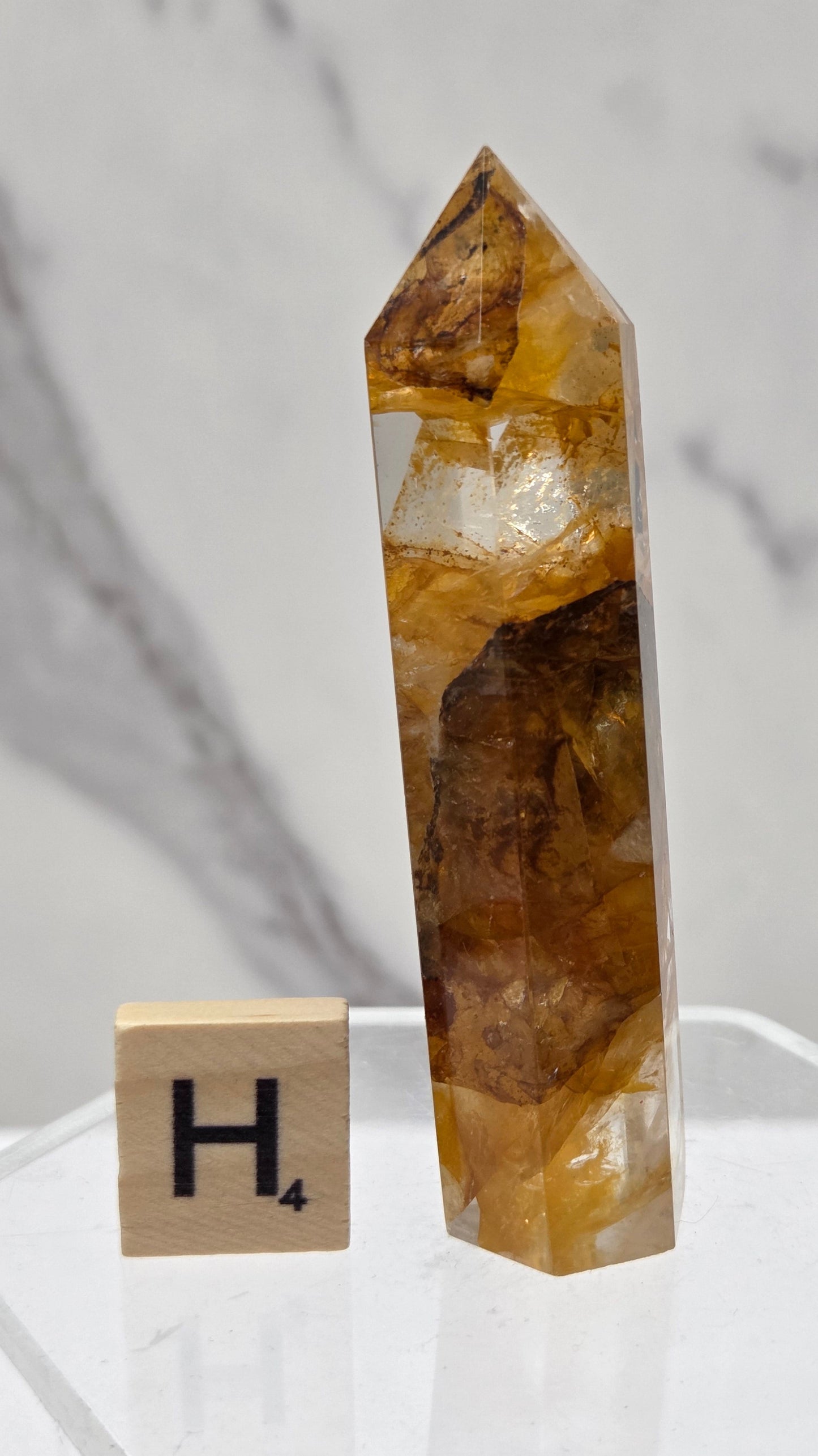 Golden Healer tower on a clear stand against a white background