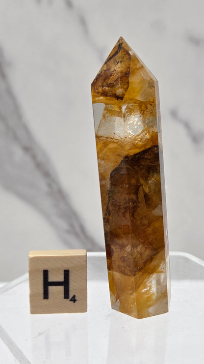 Golden Healer tower on a clear stand against a white background